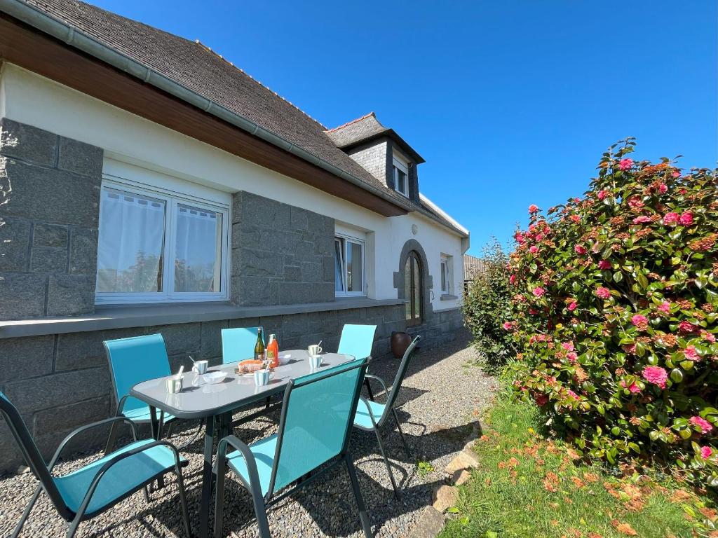 a table and chairs in front of a house at Maison spacieuse pour 8 personnes, proche GR34 in Sibiril