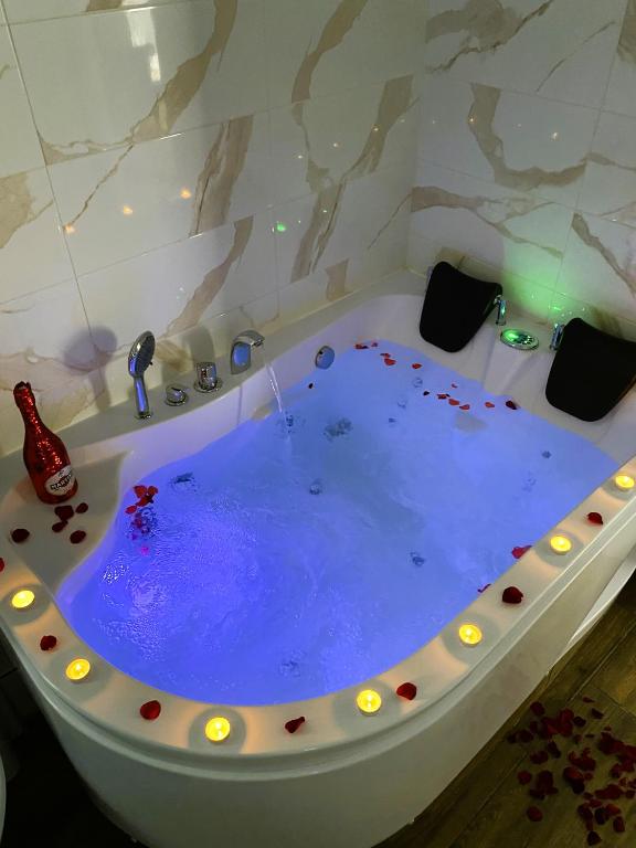 a bath tub with a blue water in it at Apartamenty Lux Chorzów in Chorzów