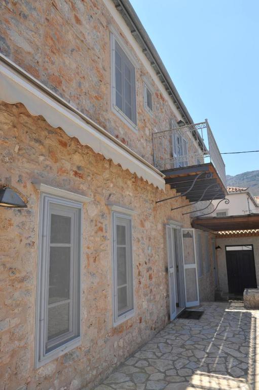 a brick building with a balcony on the side of it at Zeus House by GHH in Hydra