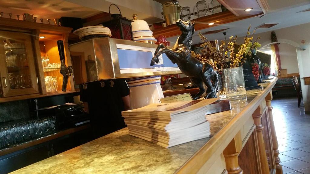 un bar con una estatua de un caballo en el mostrador en Hotel Al Cavallino, en Arnstorf