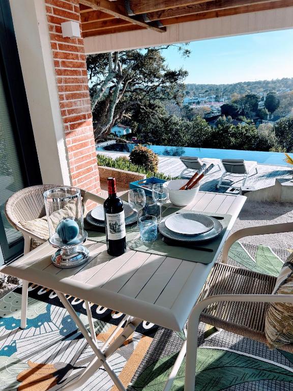 - une table blanche avec une bouteille de vin sur la terrasse dans l'établissement Peaceful Oasis in Ville d'Hiver, à Arcachon