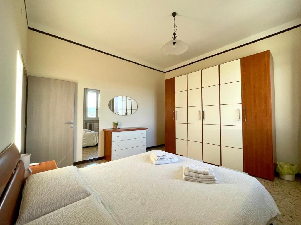 Un dormitorio con una gran cama blanca y un espejo. en A Casa Di Mima, en Civitanova Marche