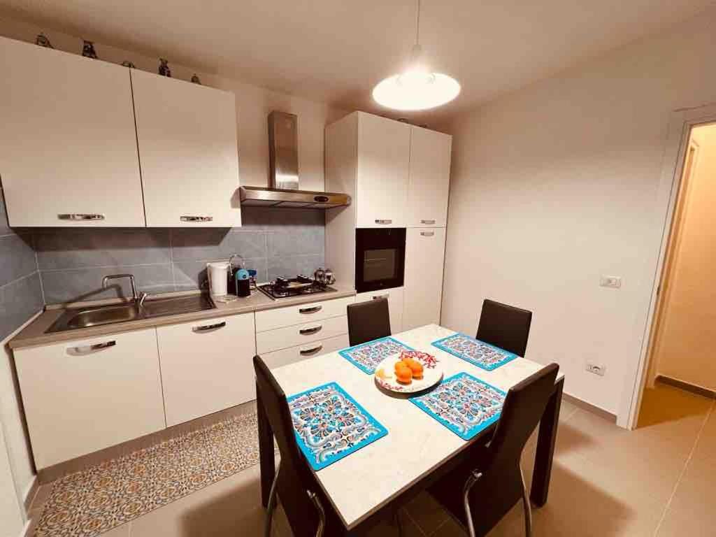 a kitchen with a table and chairs in a kitchen at Oikos Noemi in Palinuro