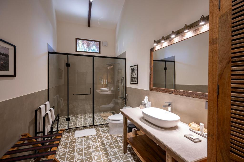 a bathroom with a sink and a shower and a toilet at Palma Beach Resort in Mandrem
