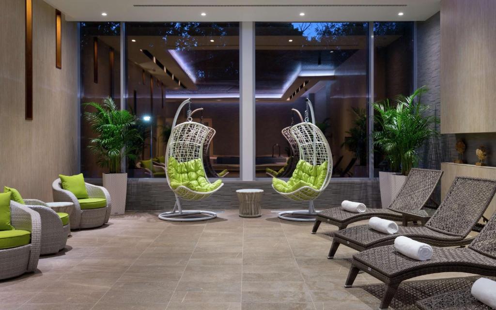 a lobby with chairs and tables in a building at DoubleTree By Hilton Moscow - Vnukovo Airport Hotel in Vnukovo