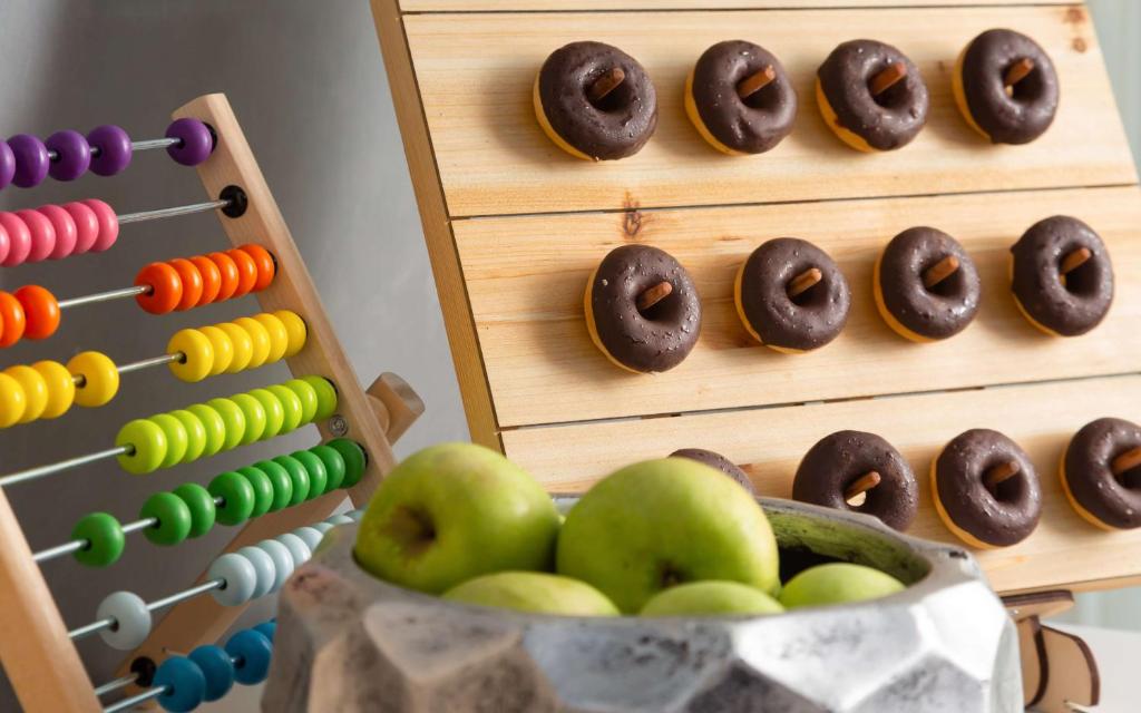 a wooden display with donuts and apples in a bowl at DoubleTree By Hilton Moscow - Vnukovo Airport Hotel in Vnukovo