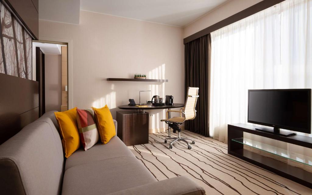 a living room with a couch and a television at DoubleTree By Hilton Moscow - Vnukovo Airport Hotel in Vnukovo