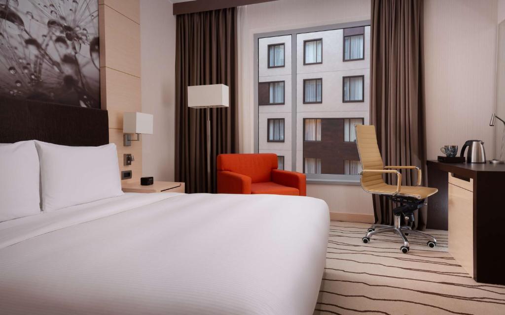 a hotel room with a bed and a desk and chair at DoubleTree By Hilton Moscow - Vnukovo Airport Hotel in Vnukovo