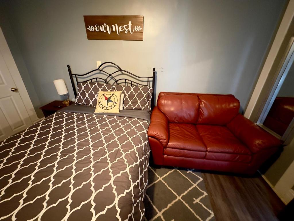 a bedroom with a bed and a leather couch at Private Studio- Queen Bed- 10 min to DT Indy in Indianapolis
