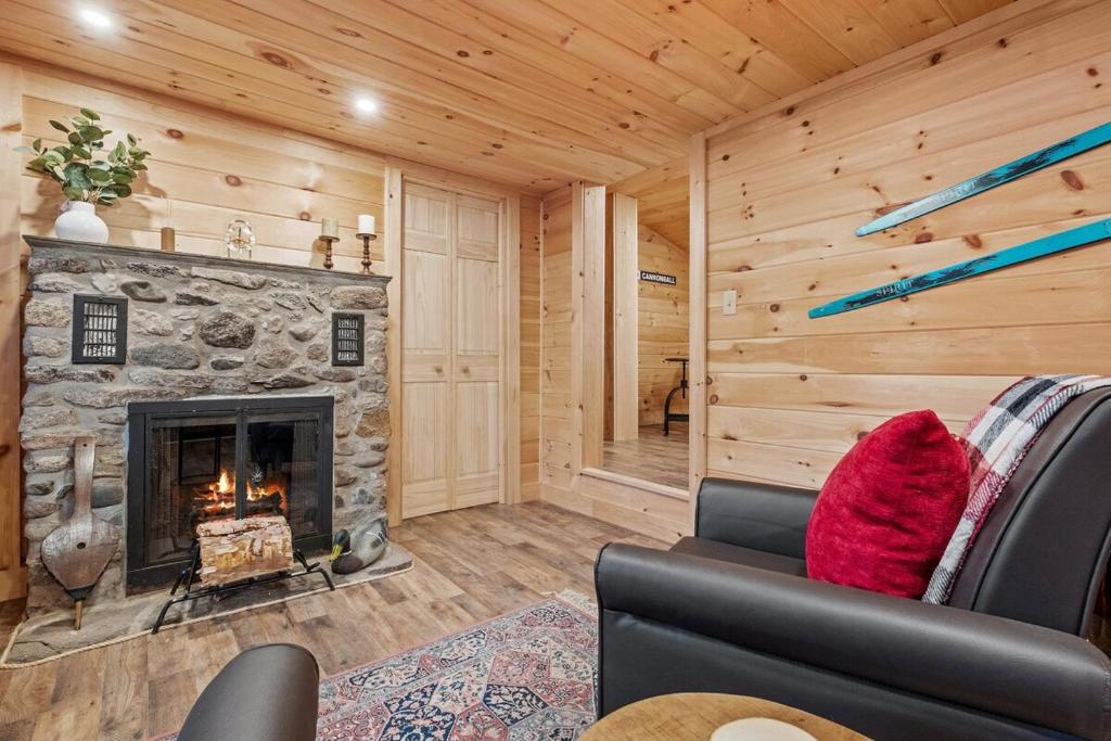 a living room with a fireplace in a log cabin at Riverfront Retreat in the White Mountains - 3BR Cozy Escape Near Ski & Hike in Bethlehem
