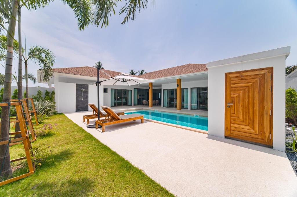 a villa with a swimming pool and a wooden door at Olive Villa - New Luxury Private Family Pool Villa 3BR Lamai in Lamai