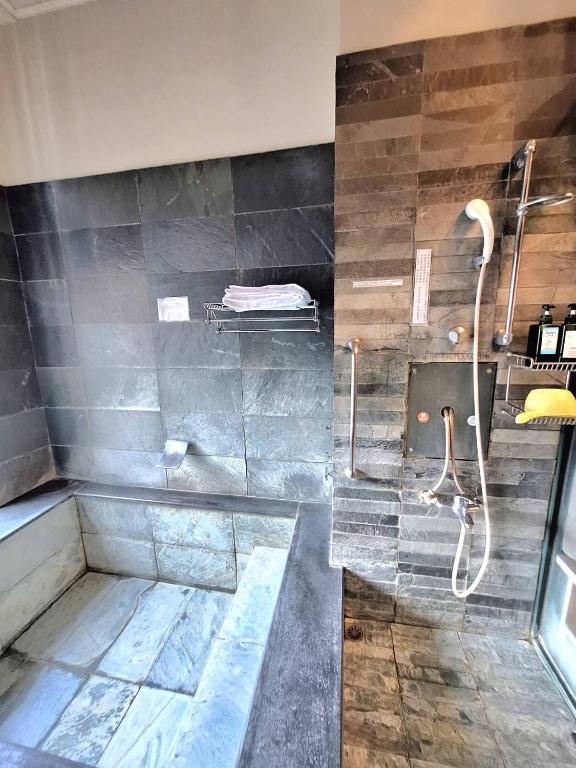 a large bathroom with a shower with a tub at Pleasant泡湯宿 in Jiaoxi