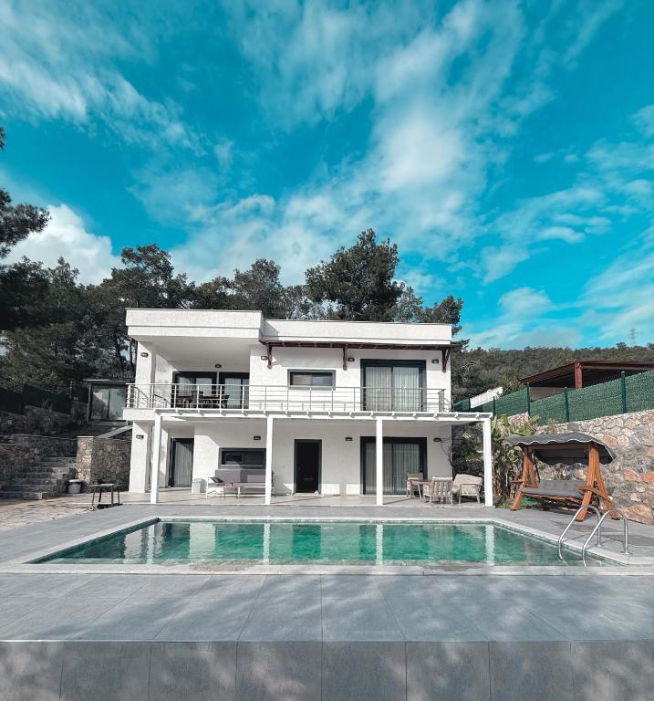 a villa with a swimming pool and a house at Bodrum Kızılağaçta özel havuzlu geniş bahçeli lüks Villa in Bodrum City
