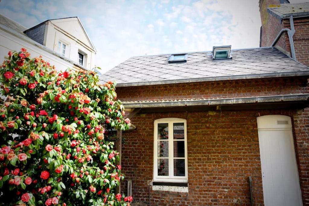 une maison en briques avec un arbre de Noël devant elle dans l'établissement Charmante maisonnette à 2 pas de la plage !, à Étretat