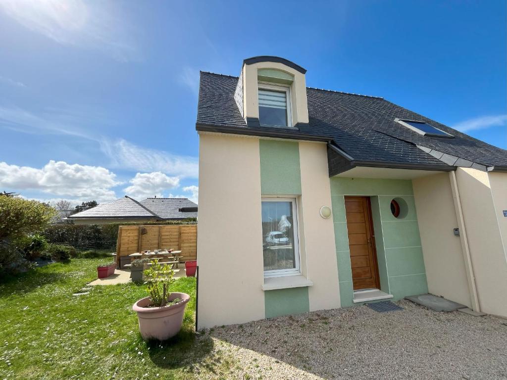 une maison blanche avec un toit noir dans l'établissement Maison des Dunes, à Plougoulm