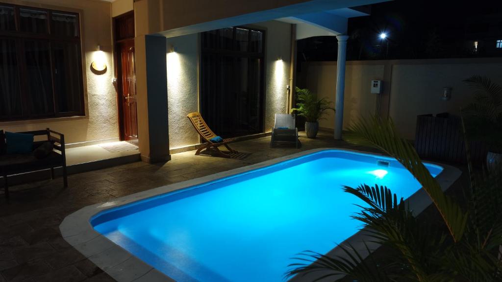 a swimming pool lit up in blue at night at Havanna in Pereybere