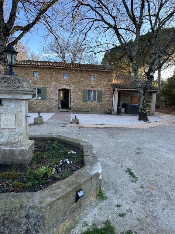 - un bâtiment en pierre avec un éclairage de rue devant dans l'établissement Mas Pepette, à Collias