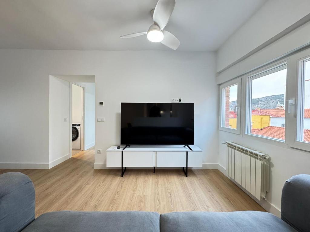 Una sala de estar con un televisor de pantalla plana grande. en Nohe, en Cuenca