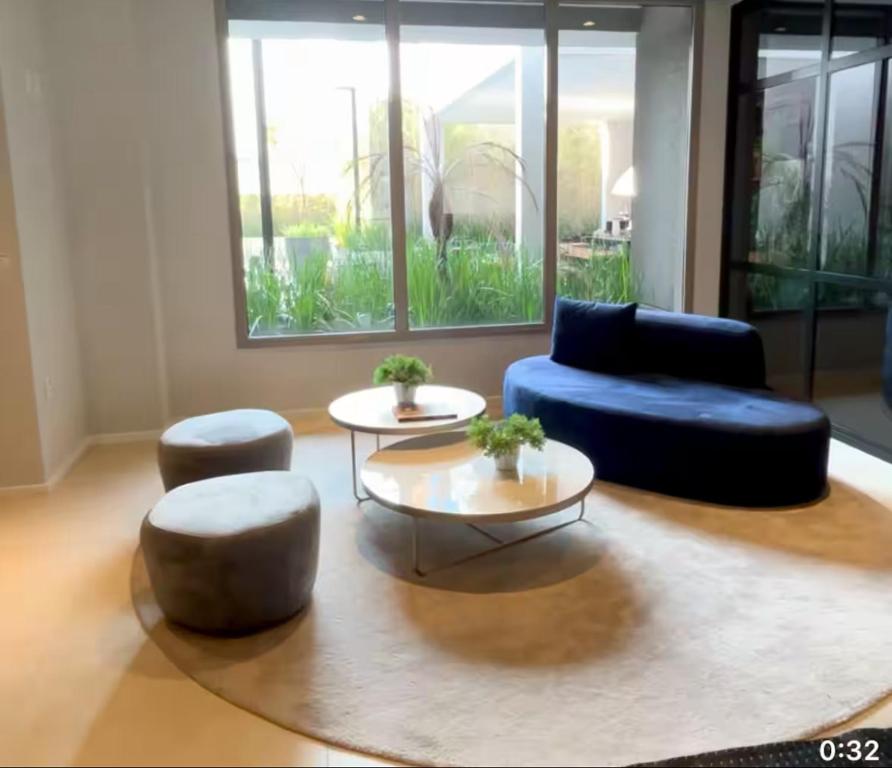 a living room with two chairs and a blue couch at AP aconchegante na Vila Madalena in Sao Paulo