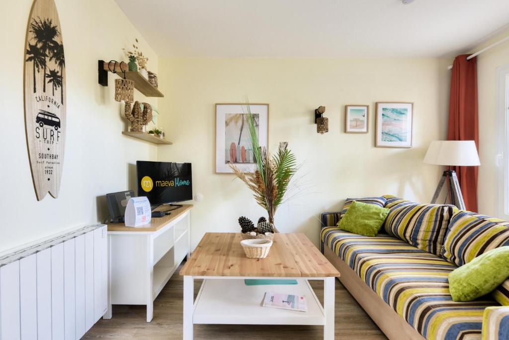 un salon avec un canapé et une table basse dans l'établissement Les Maisons de Lacanau les Pins - maeva Home - Maison charmante avec jardin 3 pièces 4 personnes - Prestige - super Home MAE-7455, à Lacanau