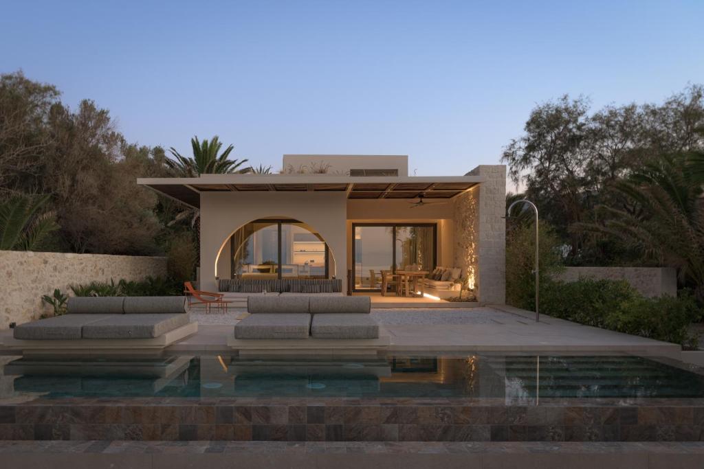 a house with a pool in front of it at Dyo Beach Suites in Rethymno Town