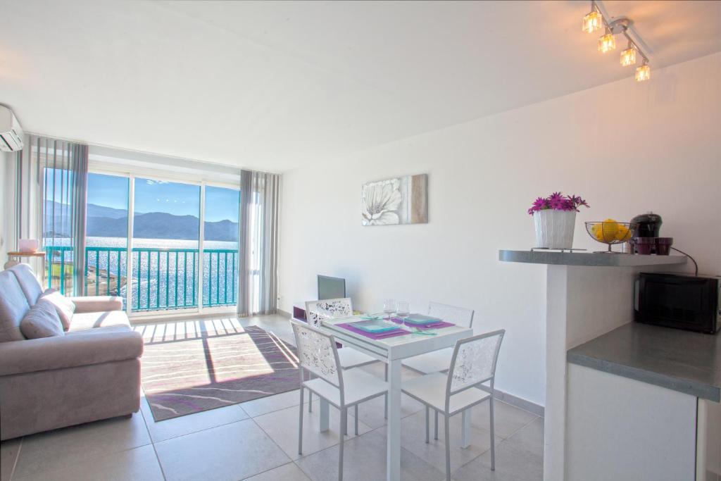 cocina y sala de estar con mesa y sillas en Studio Marine du Soleil, en Patrimonio