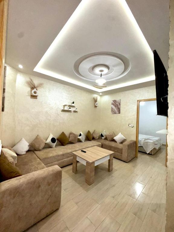 a living room with a couch and a table at Appartement moderne & calme proche plage Saïdia in Saidia 