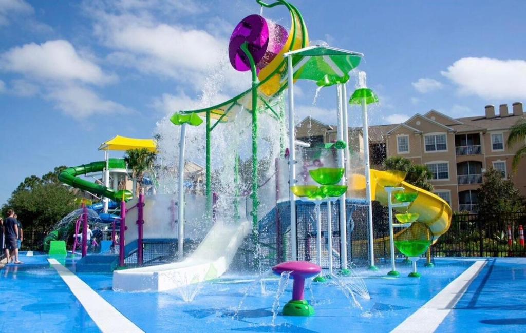 a pool with a water park with a water slide at New Luxury Townhome near Disney in Orlando