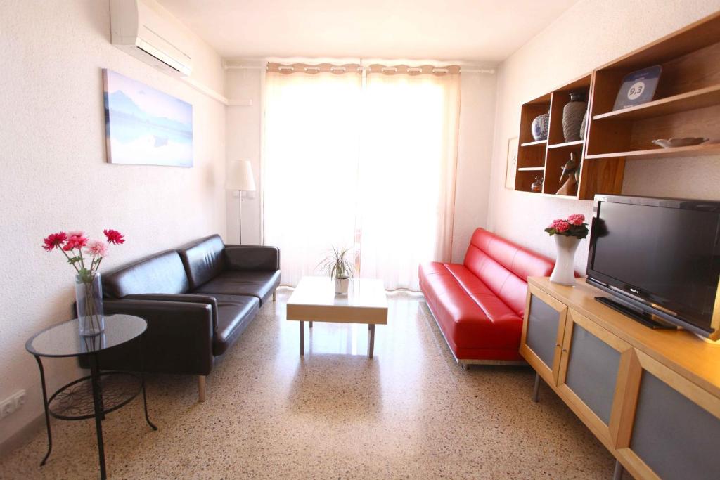 a living room with a couch and a tv at Bordeta in Barcelona