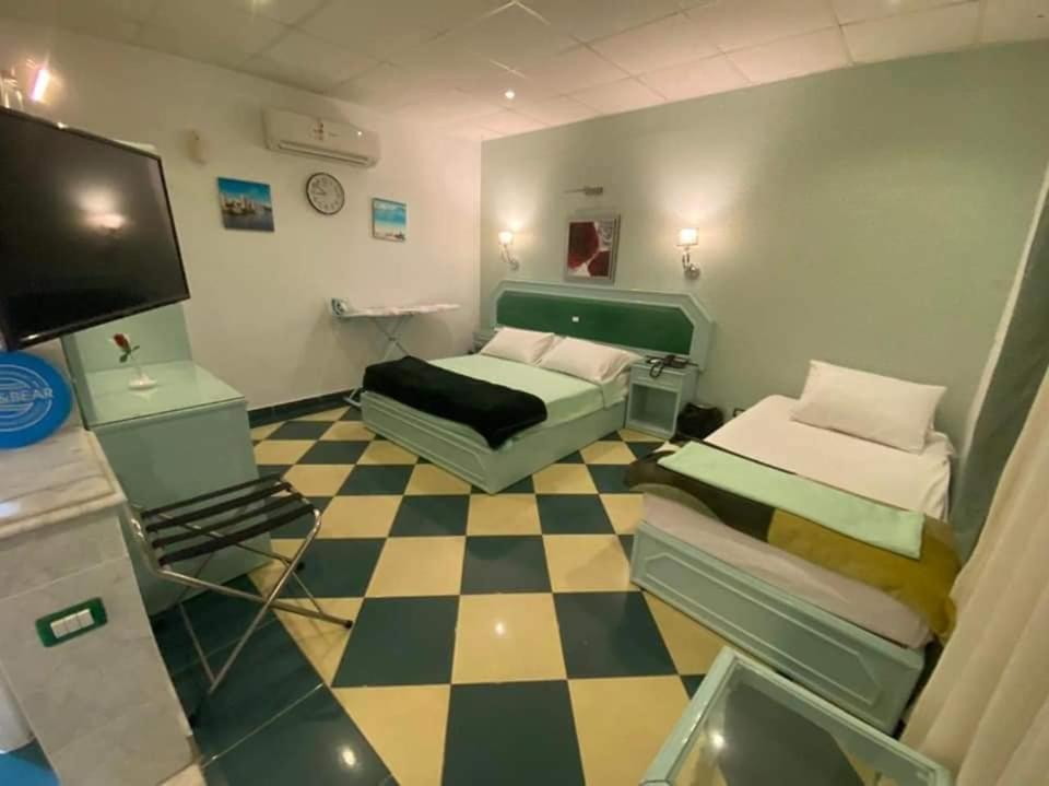 Una habitación con dos camas y suelo de cuadros. en Riviera Beach Chalets, en Marsa Matruh