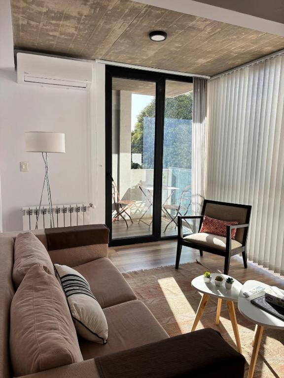 a living room with a couch and a table at Moderno y luminoso departamento in Tandil