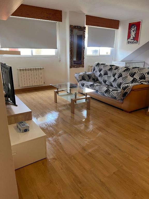 a living room with a couch and a tv at Tomillaron House in Las Rozas de Madrid