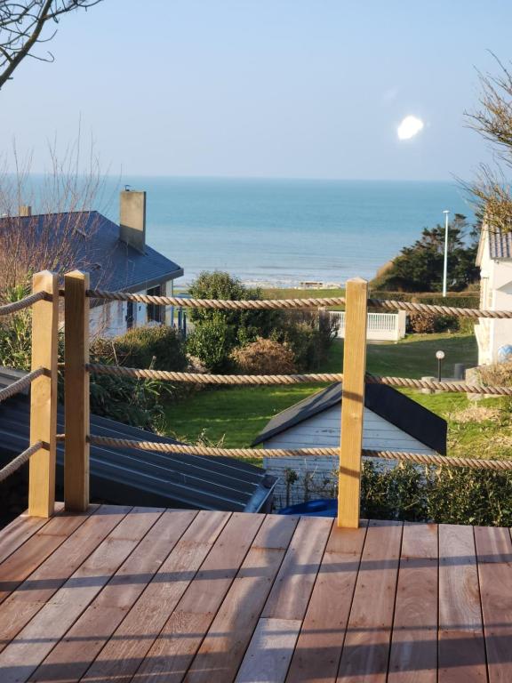 une terrasse en bois avec l'océan en arrière-plan dans l'établissement Je m'y plais, à Sainte-Marguerite