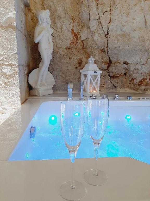 2 bicchieri da vino seduti accanto alla piscina di GB Grotta Bianca a Ostuni