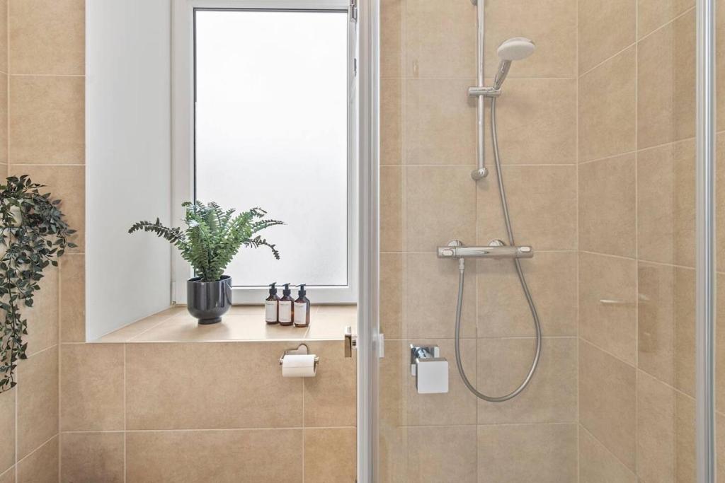 a bathroom with a shower with a glass door at Fast Wifi I 4 min to U3 Zipperer Straße in Vienna
