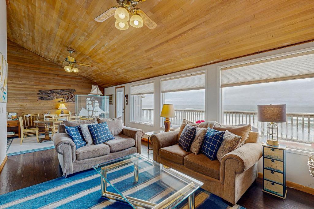 a living room with two couches and a table at At The Seaside in Lincoln Beach