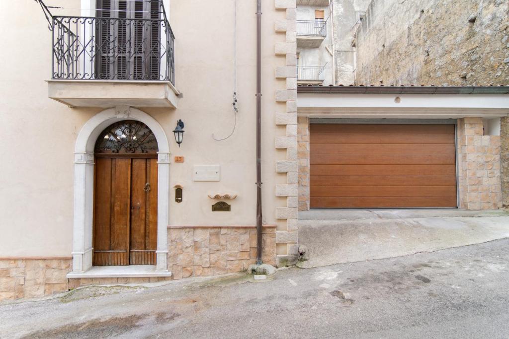 a building with a wooden door and a garage at Antica dimora del Carmine in Camerota