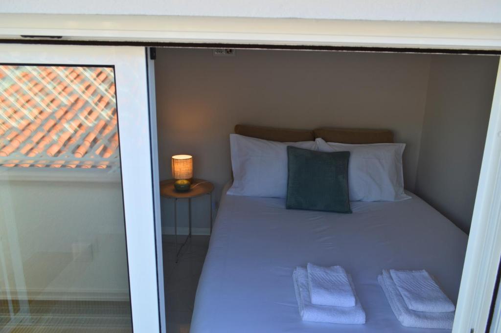 a bed in a small room with a window at Porta 4 in Nazaré
