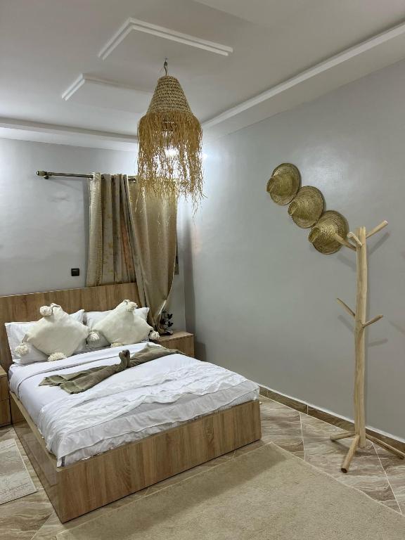 una camera da letto con un letto e un lampadario di Tasurft house Taghazout a Taghazout