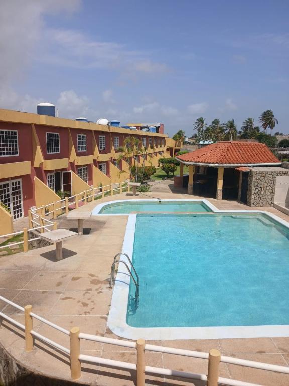 a resort with a large swimming pool next to a building at Águila Marina Suites in Chichiriviche