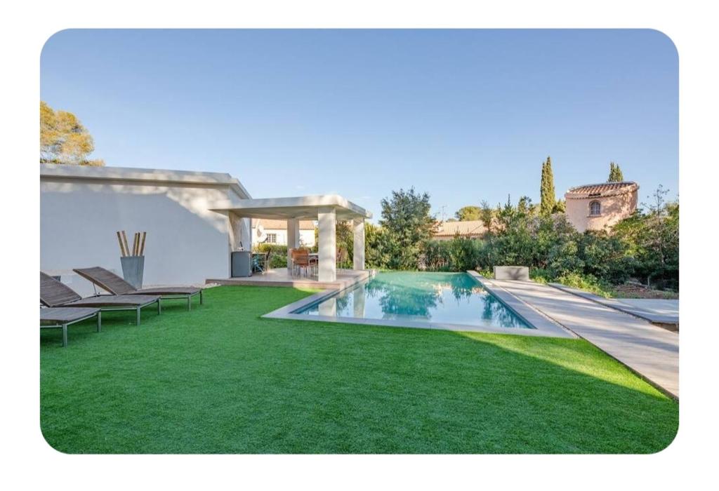 une cour avec une piscine et de l'herbe verte dans l'établissement Villa tout confort avec piscine, à Saint-Raphaël