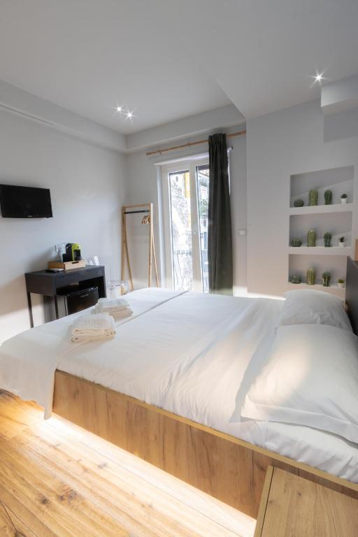 a large bed with a wooden frame in a bedroom at Taormina Boutique Rooms in Taormina