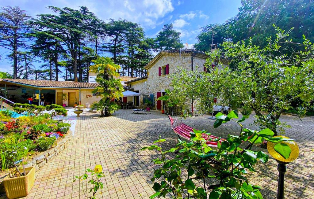 une cour d'un bâtiment avec des arbres et des plantes dans l'établissement Beautiful Home In Saulce Sur Rhône, à Saulce-sur-Rhône