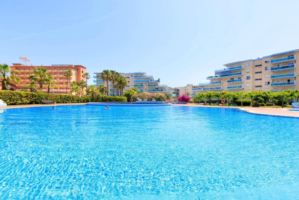 a large swimming pool in a city with tall buildings at New Juncos 2 Planetcostadorada in La Pineda