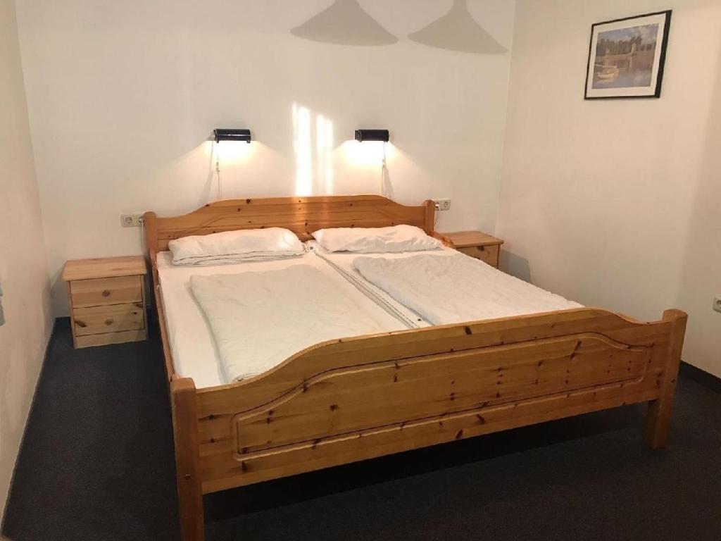 a bedroom with a wooden bed with two pillows at Ferienhaus in Zandt mit Kleiner Terrasse in Zandt