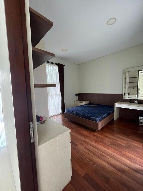 a bedroom with a bed and a wooden floor at Cipedes Mansion in Bandung