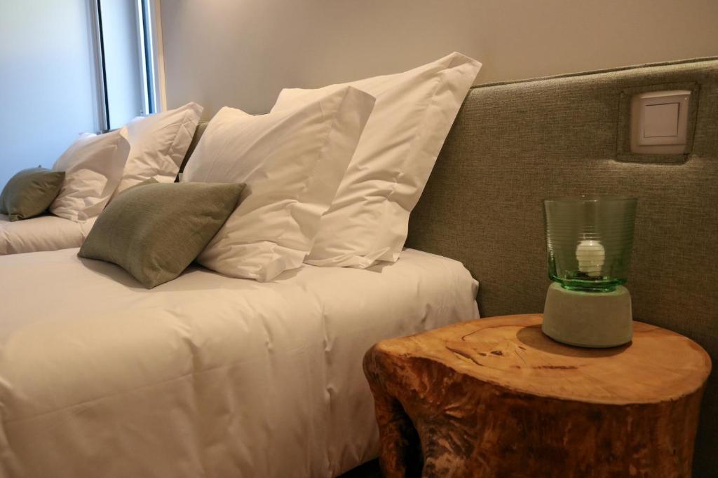 - un lit avec des oreillers blancs et une table en verre dans l'établissement Story Studio Aveiro Ria - Lagoon, à Aveiro