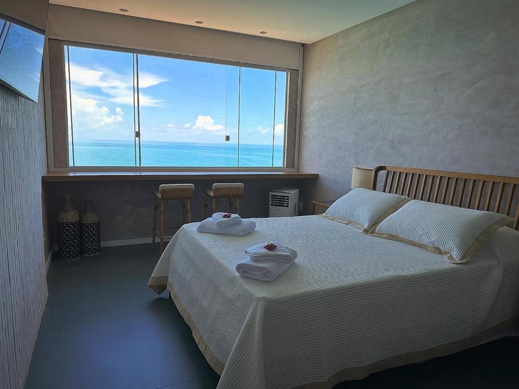 um quarto com uma cama e uma janela grande em Guarapari Apart1315 em Guarapari