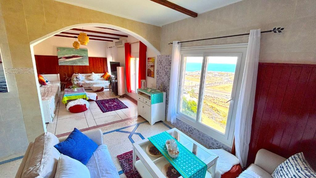 un salon avec une pièce avec une grande fenêtre dans l'établissement Heenalu surf camp, à Tamraght Ouzdar