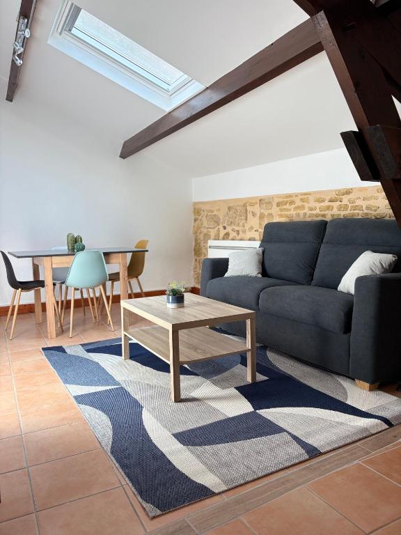 un salon avec un canapé bleu et une table dans l'établissement Barrio Cyrano Appartement-Centre Historique, à Bergerac